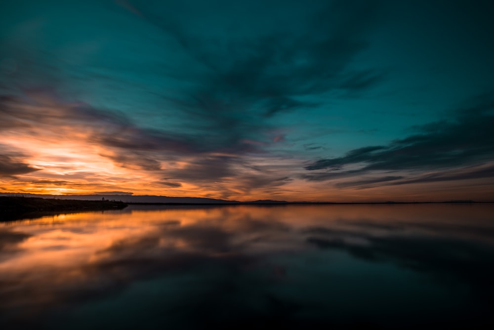 Foto eines Gewässers und eines Sonnenuntergangs