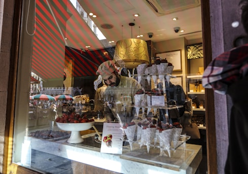 Customer happily collecting a custom edible arrangement from a stylish storefront.