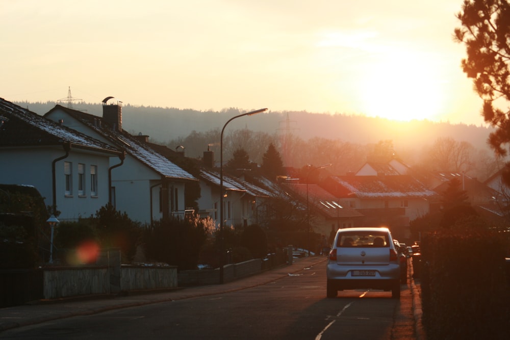 car passing through houses during golden hour