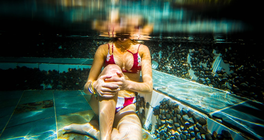 Frau sitzt unter Wasser