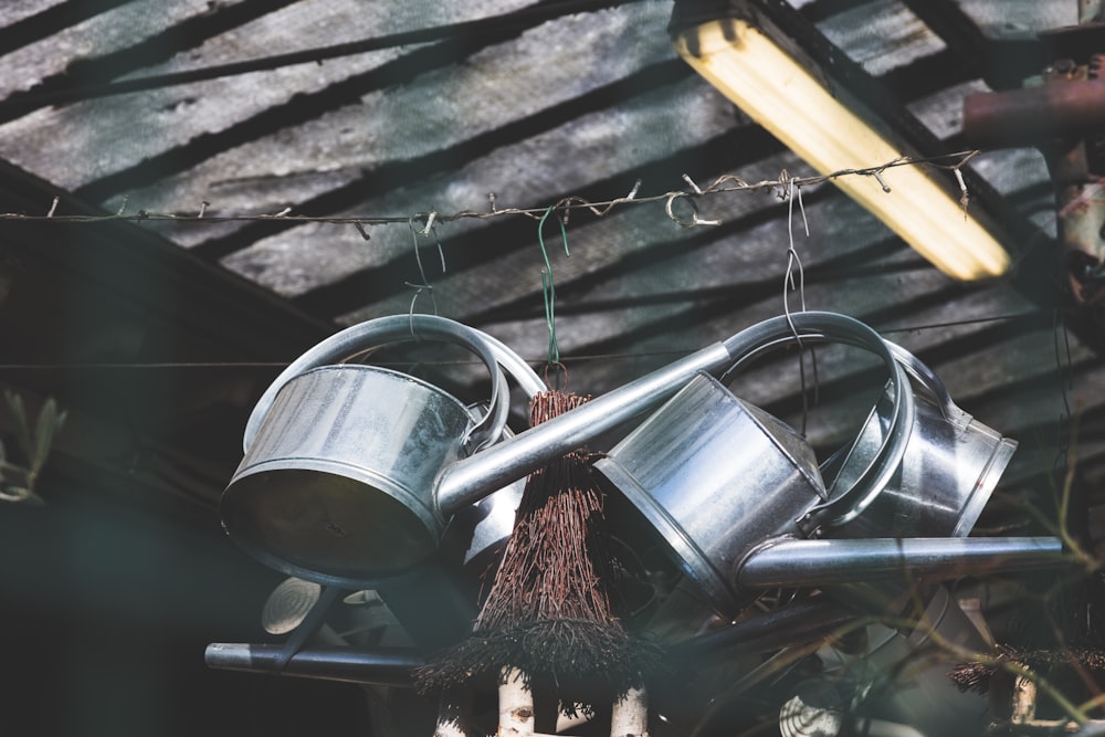 three hanged gray watering cans