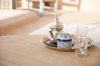 gray teapot set in tray place on brown table outdoors