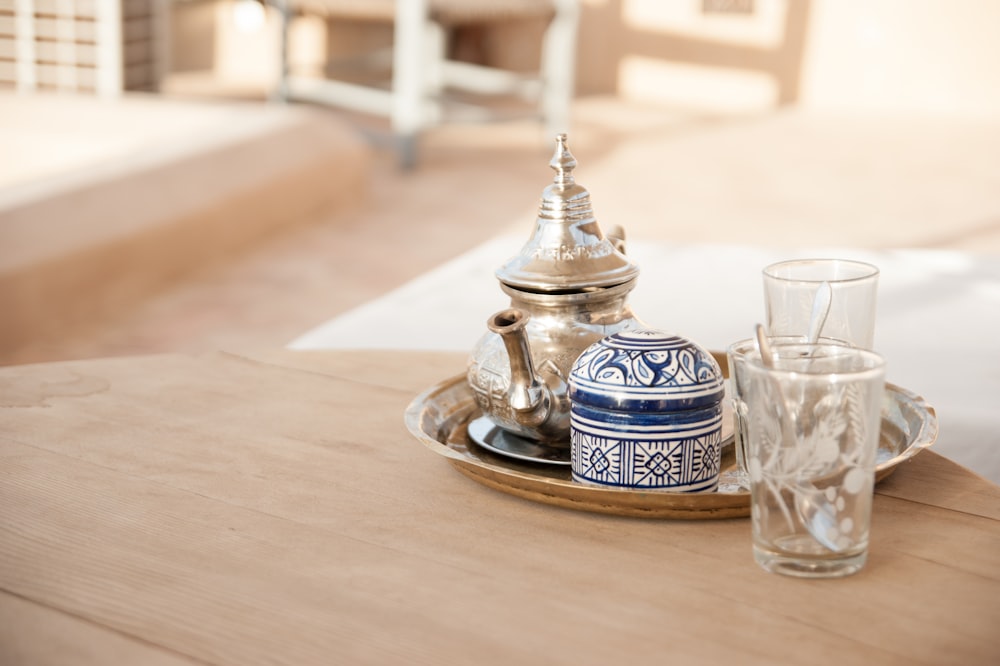 gray teapot set in tray place on brown table outdoors