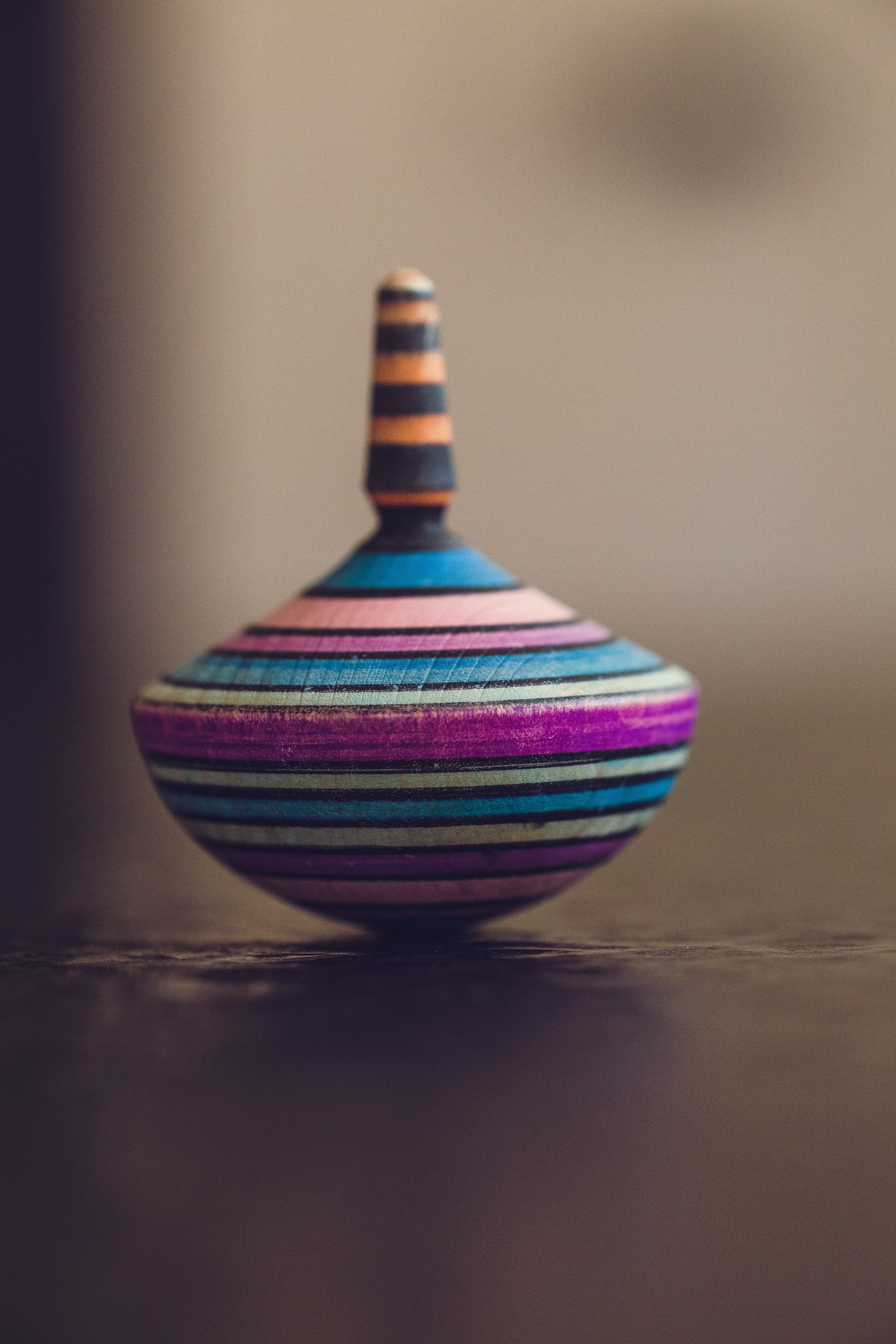 tilt-shift photography of multicolored spin top on brown surface