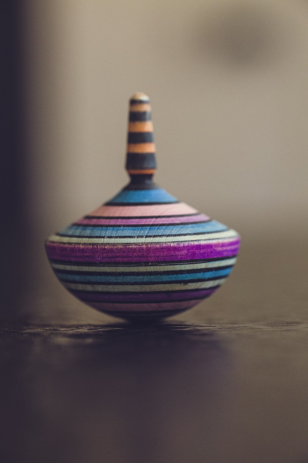 tilt-shift photography of multicolored spin top on brown surface
