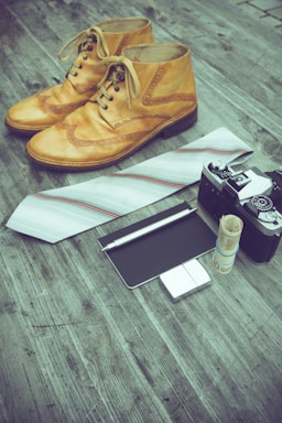 A close-up of a stylish leather shoe resting beside a handwritten note and a vintage pen.