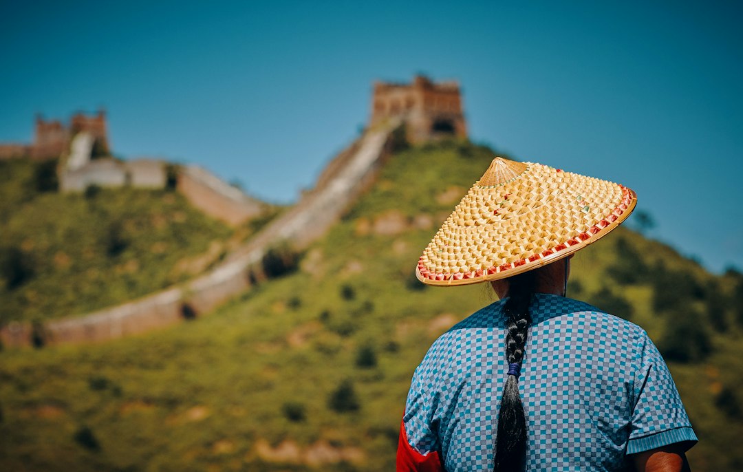 woman wearing hat facing The Great Wall of China, China