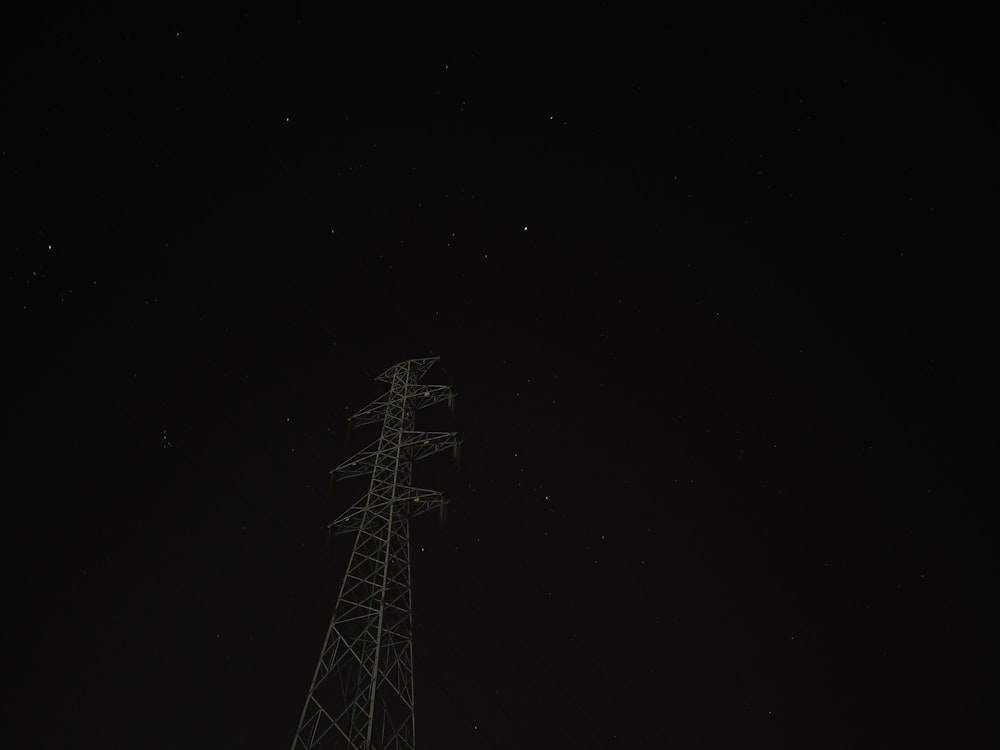 Una torre de radio por la noche con estrellas en el cielo