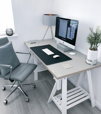 gray leather office rolling armchair beside white wooden computer desk