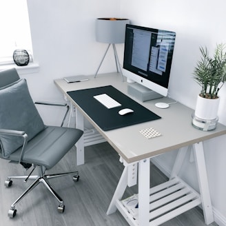 gray leather office rolling armchair beside white wooden computer desk