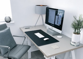 gray leather office rolling armchair beside white wooden computer desk