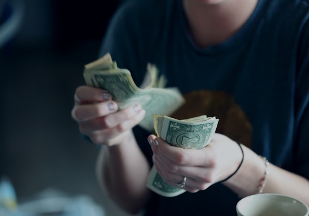 focus photography of person counting dollar banknotes