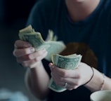 focus photography of person counting dollar banknotes