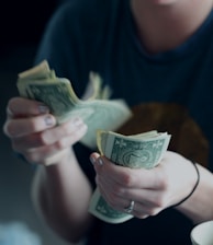 focus photography of person counting dollar banknotes