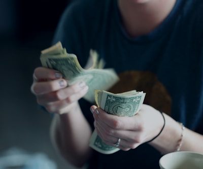 focus photography of person counting dollar banknotes