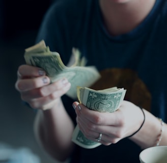 focus photography of person counting dollar banknotes