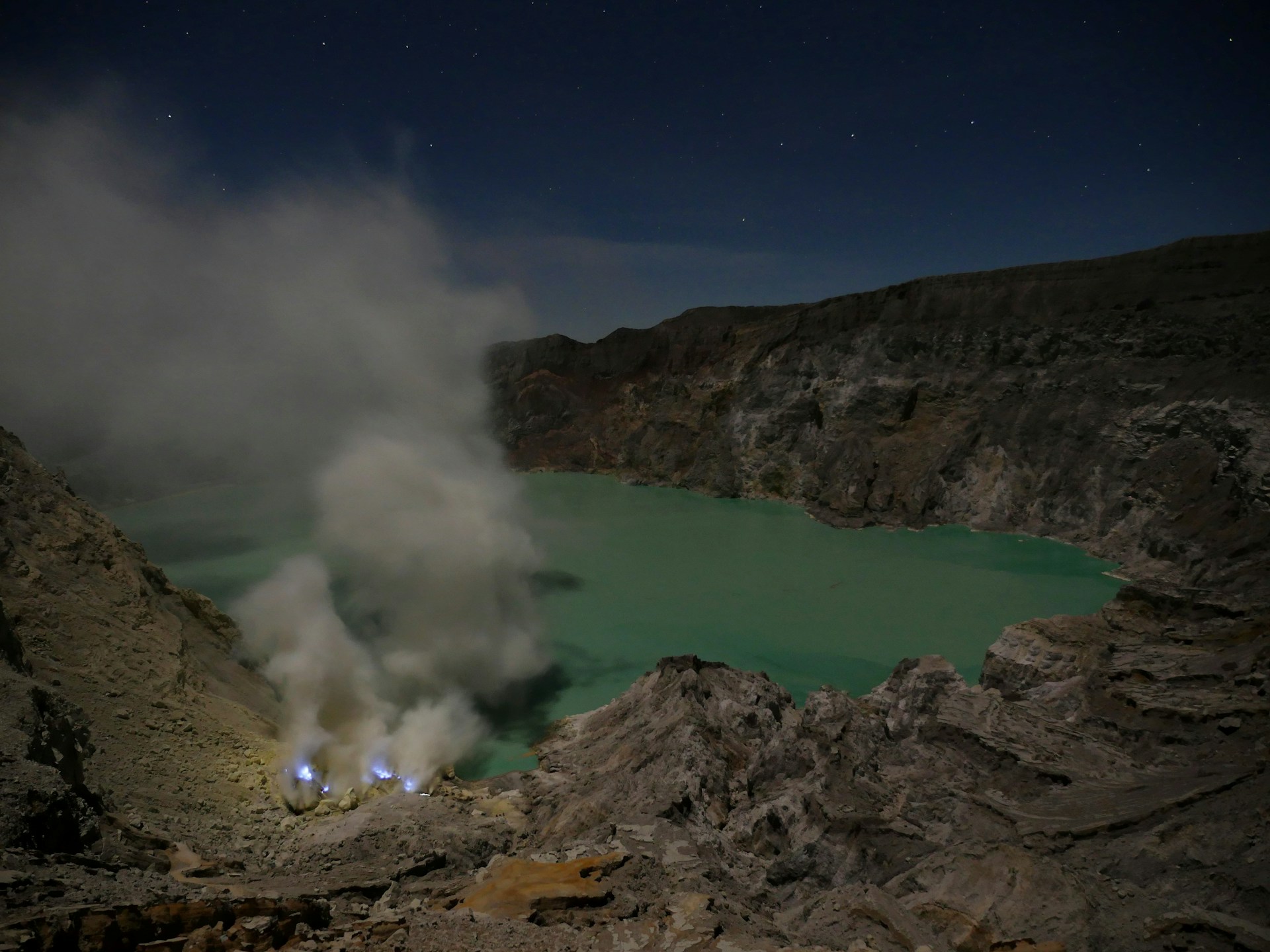 The vibrant turquoise waters of Ijen Crater lake glowing under the early morning light.
