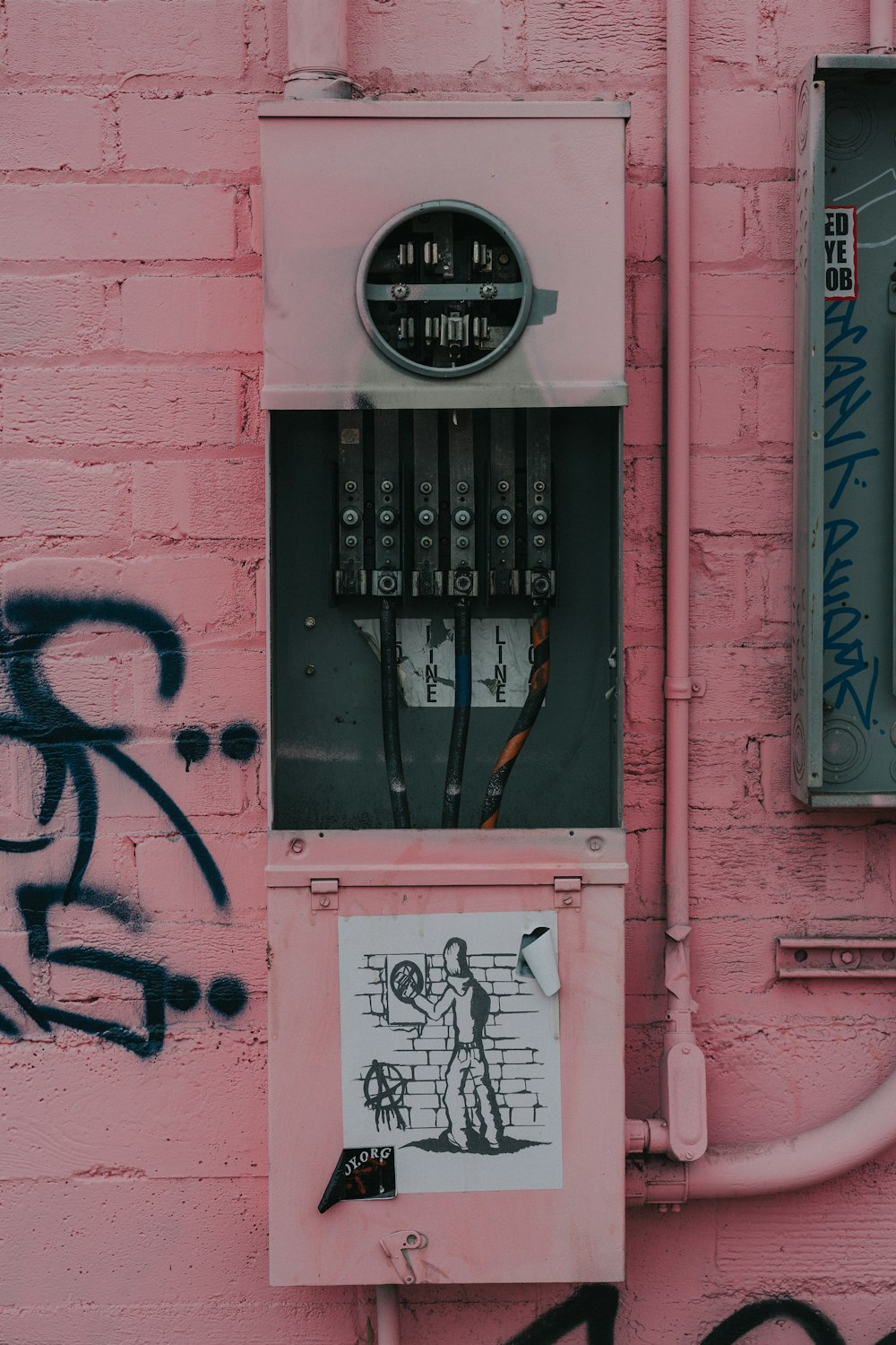 Photographie d’un tableau de distribution avec un autocollant graffiti