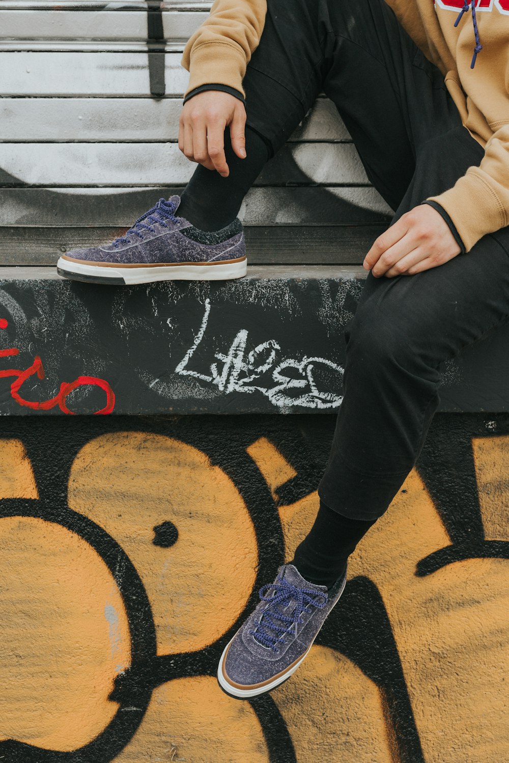 person sitting on gray concrete surface during daytime