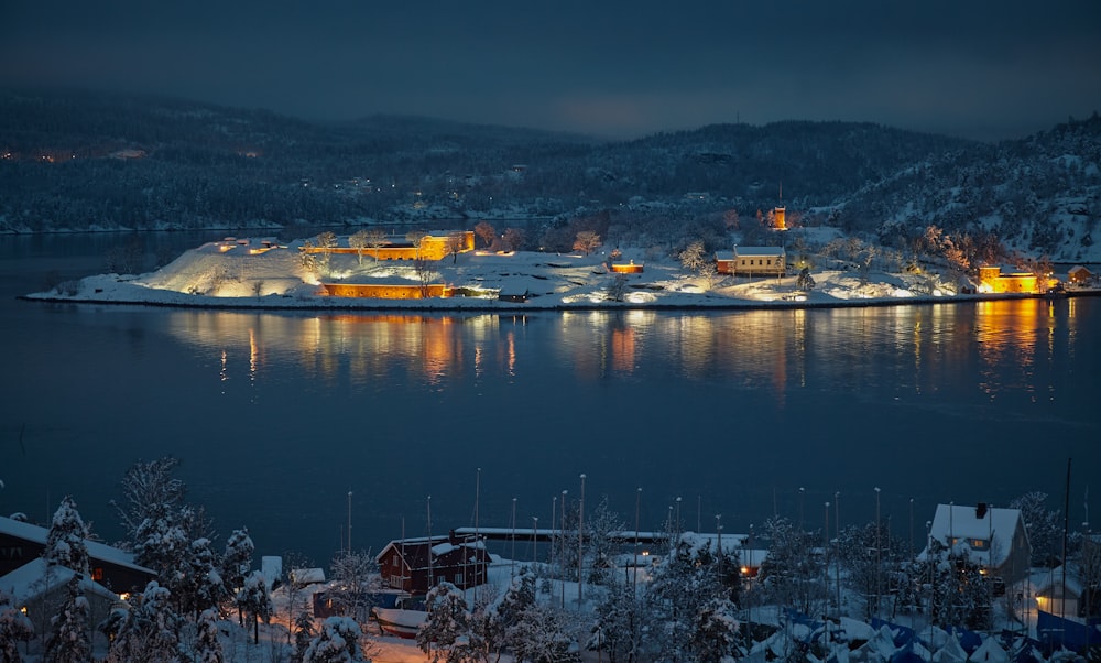 aerial photography of village surrounded by body of water coated by snow ice