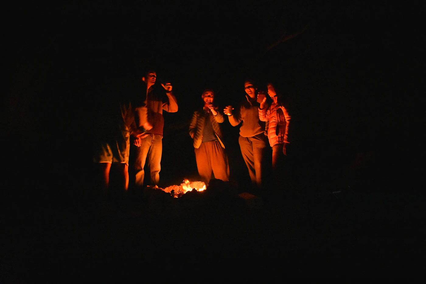 People gathered around a bonfire at night