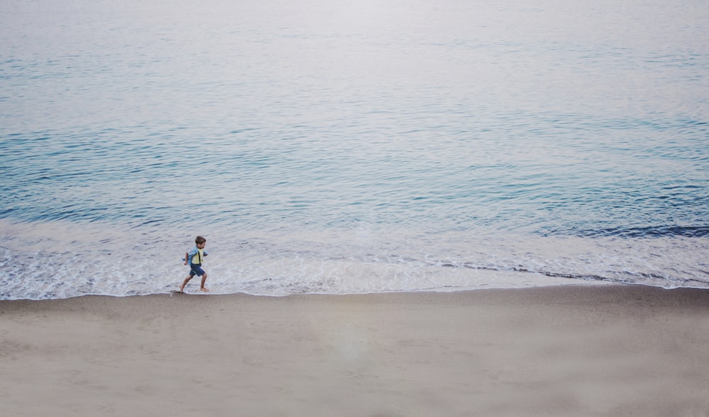person running on seashore during daytime