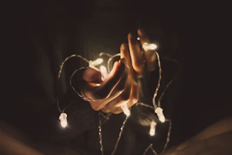 A warm, softly lit photo of hands gently holding a glowing star-shaped light, symbolizing hope and connection.