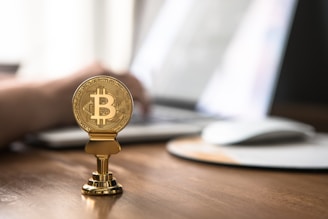 gold-colored bitcoin on brown table