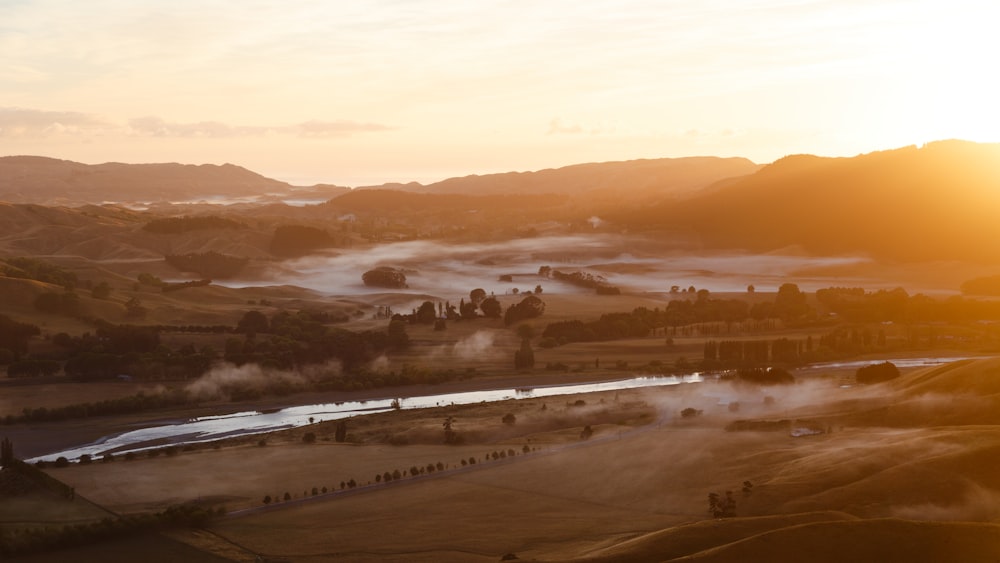 aerial photography of body of water between field during golden hour