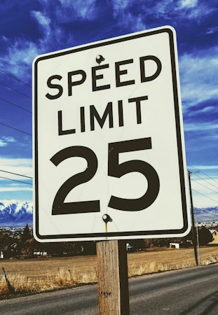 A white 25 mph speed limit sign along a residential street, like the lower limits the Las Vegas City Council approved on Oct. 7, 2026