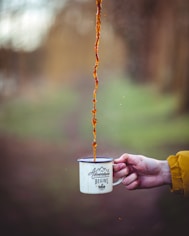 brown liquid poured on white enamel cup