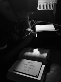 A close-up of a man journaling in a cozy, softly lit room, reflecting personal growth.