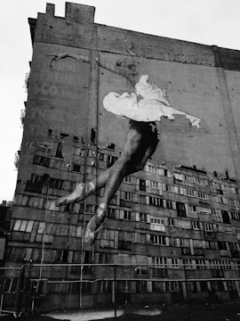 Close-up shot of Juan Dona painting a colorful breakdancer on a large urban wall.