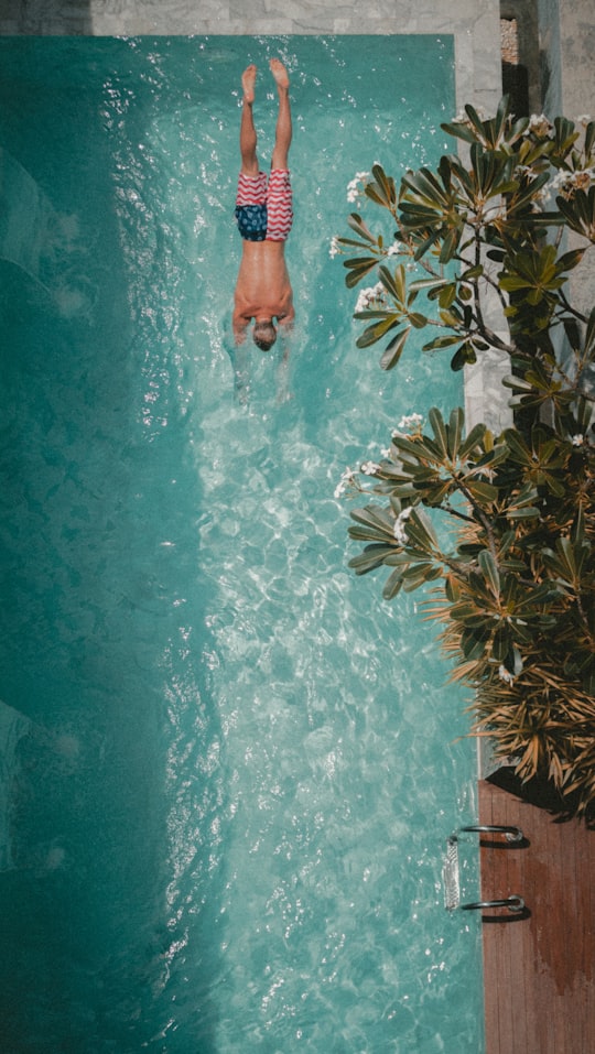 high angle photography of man diving towards the pool in Phuket Thailand