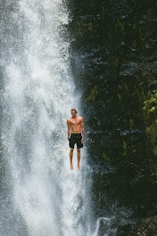 man jumps in waterfalls