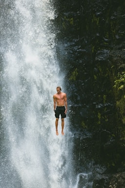 man jumps in waterfalls