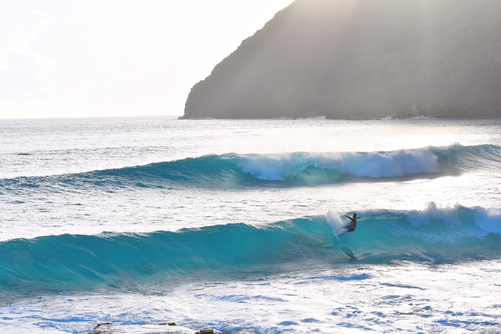 Persona che cavalca un'onda usando una tavola da surf