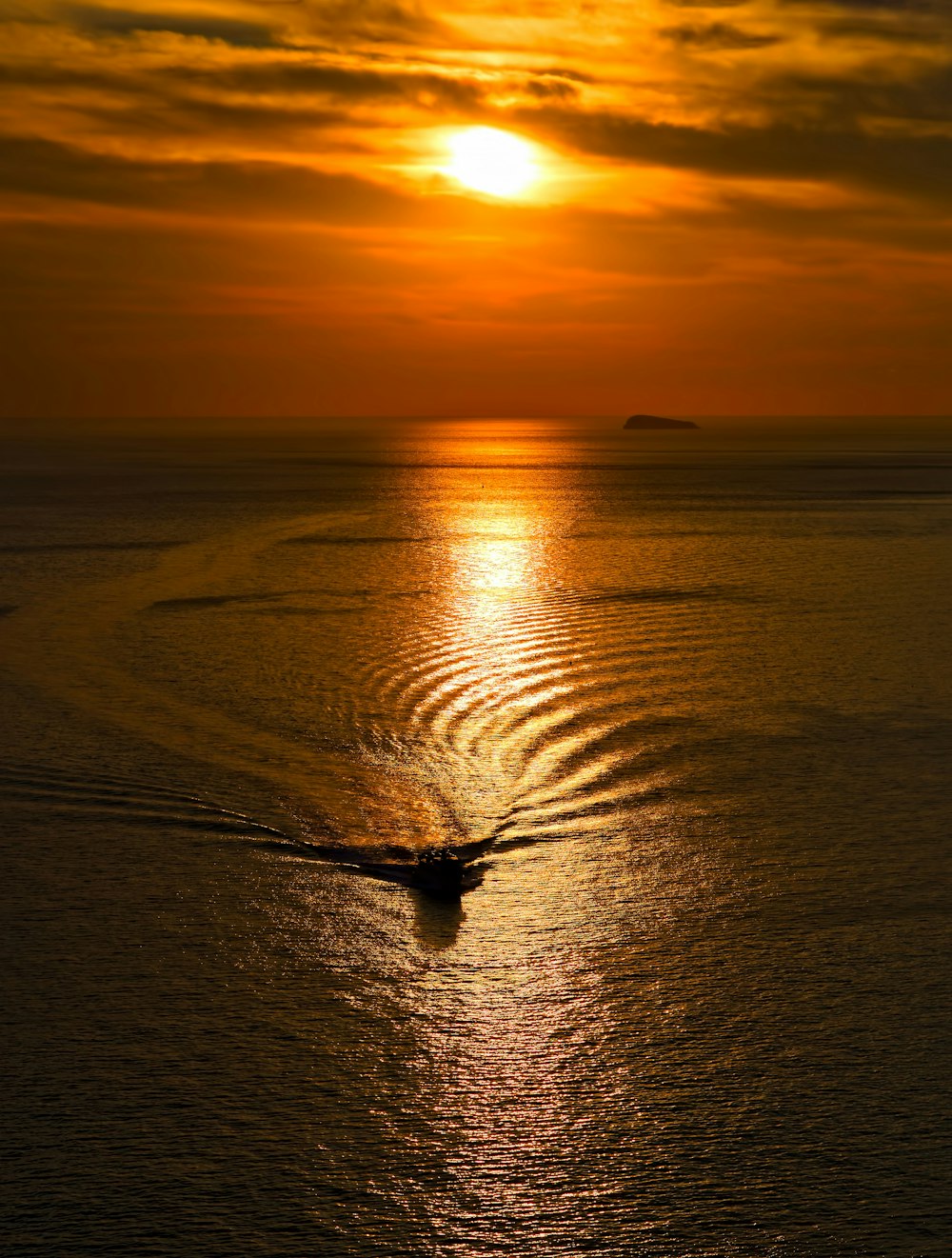 boat riding on the body of water during golden hour