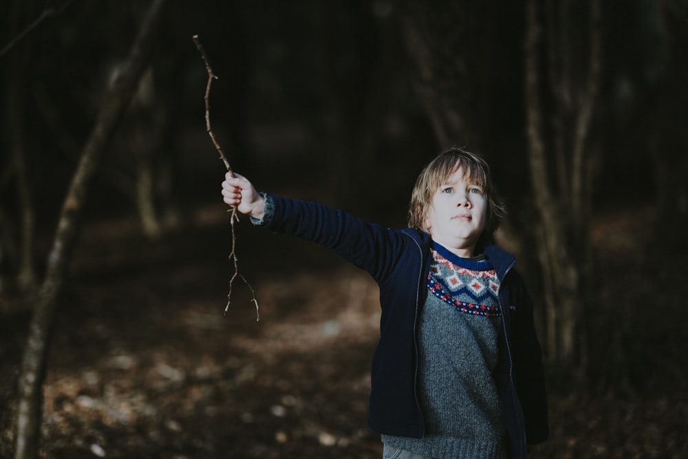 boy holding brown stick