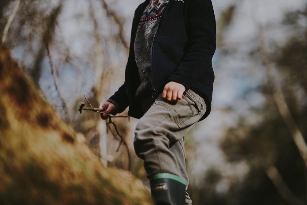 selective focus photography of person standing on tree