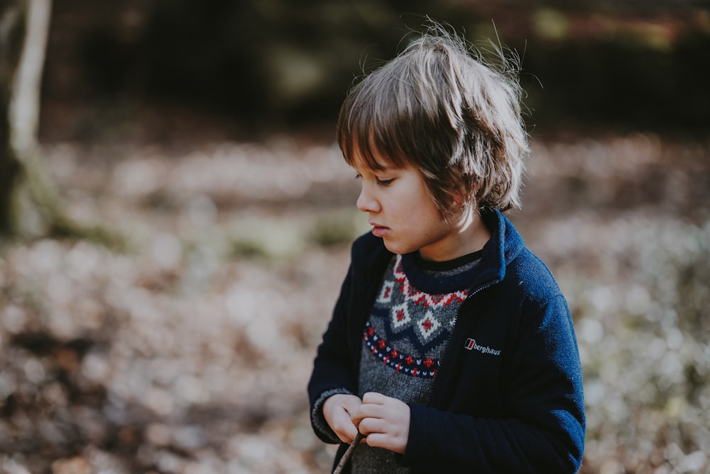 selective focus photography of boy wearing coat