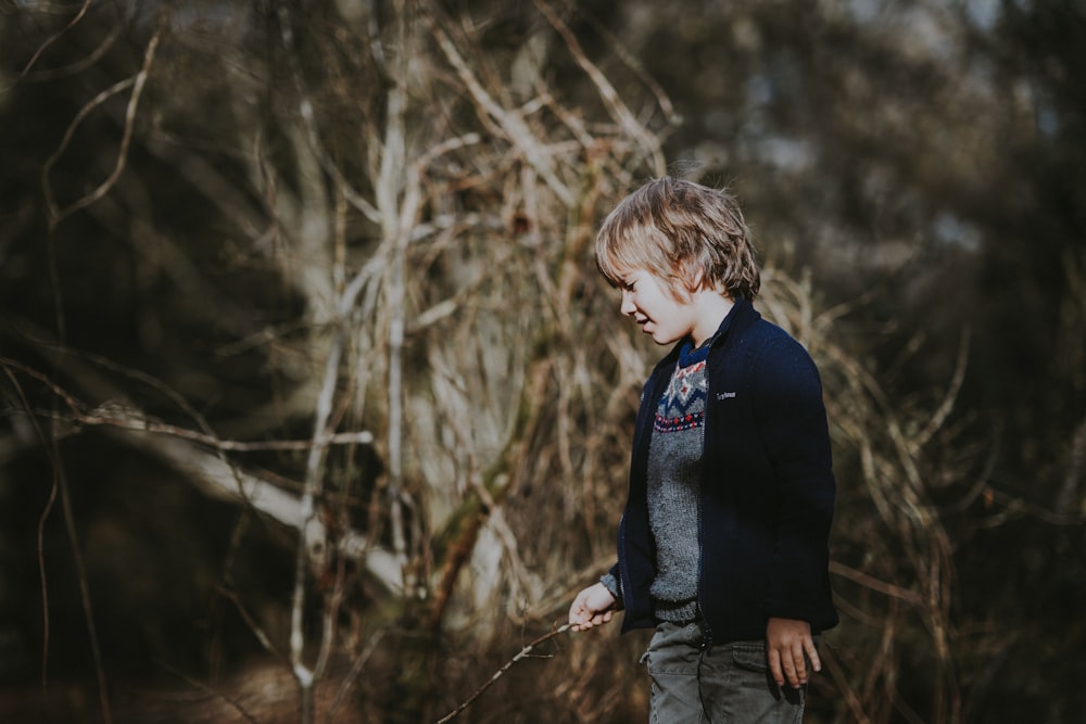 boy standing near brance during daytime