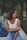 woman sitting on edge of swimming pool near palm tree