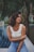 woman sitting on edge of swimming pool near palm tree