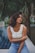 woman sitting on edge of swimming pool near palm tree