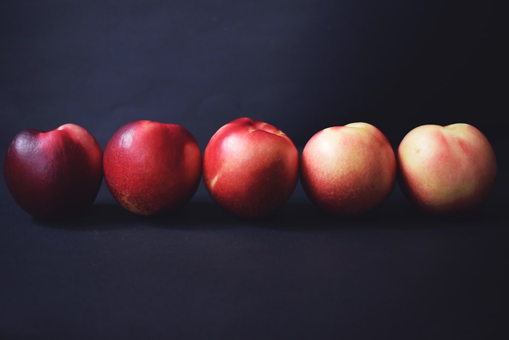 Cinco manzanas sobre una superficie negra