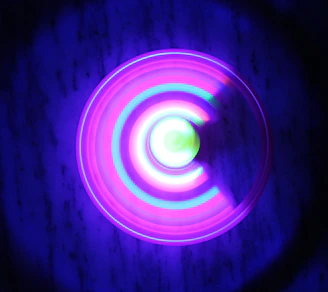 A glowing scarab symbol intertwined with sacred geometry patterns, pulsating softly with neon purple and gold hues against a dark background.