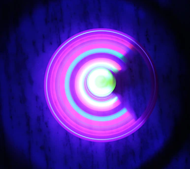 A glowing scarab symbol radiating neon purple and gold light against a deep charcoal background, surrounded by softly pulsing sacred geometry patterns.