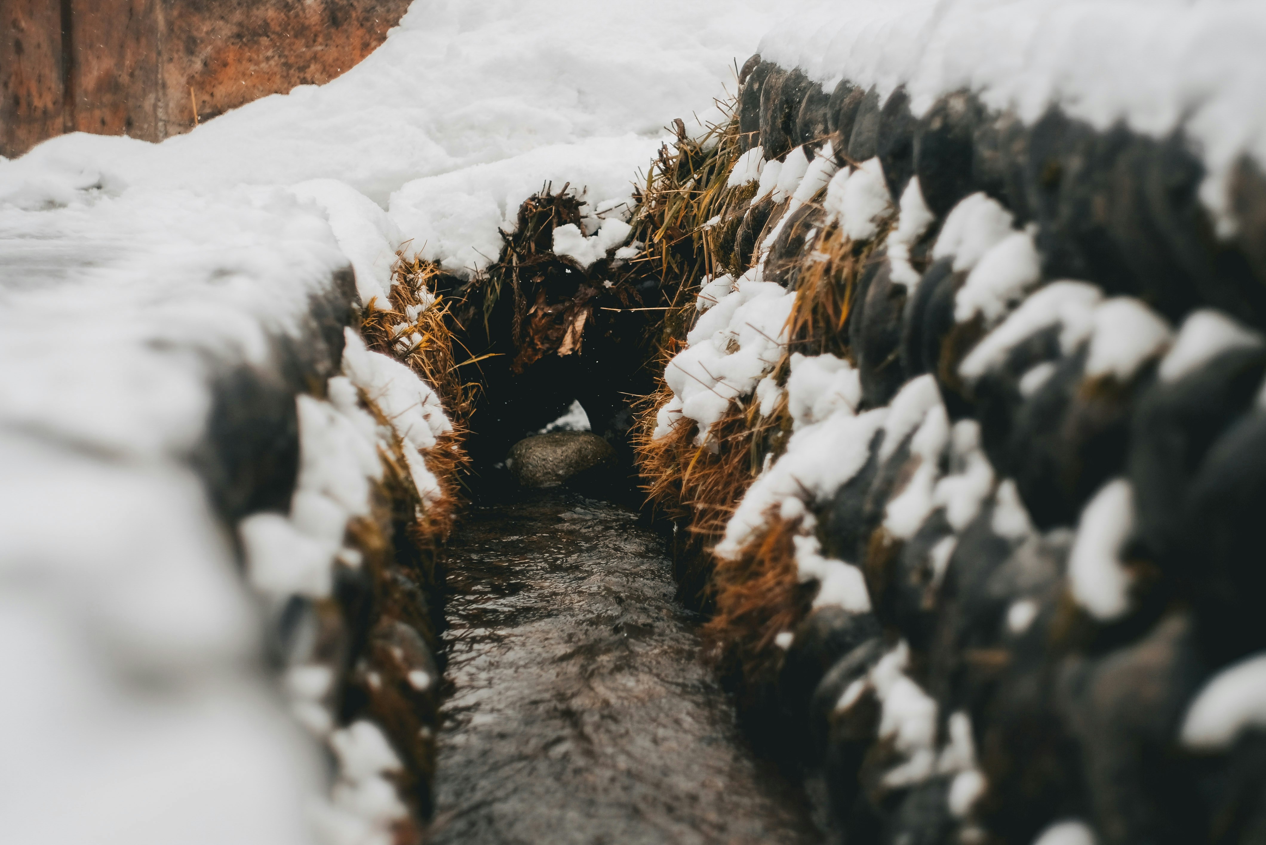 pathway between stack of hay with snows