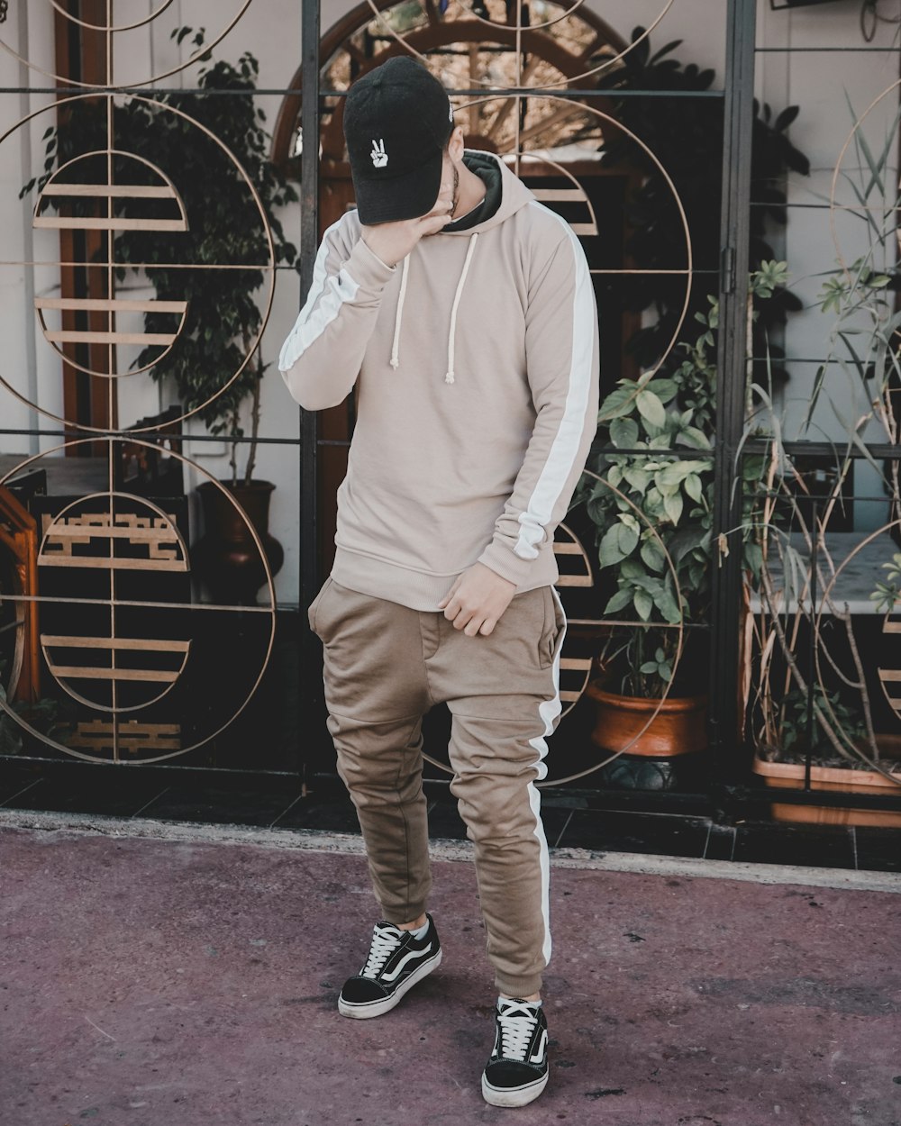 man covering his face with his right hand in front of gray metal rack